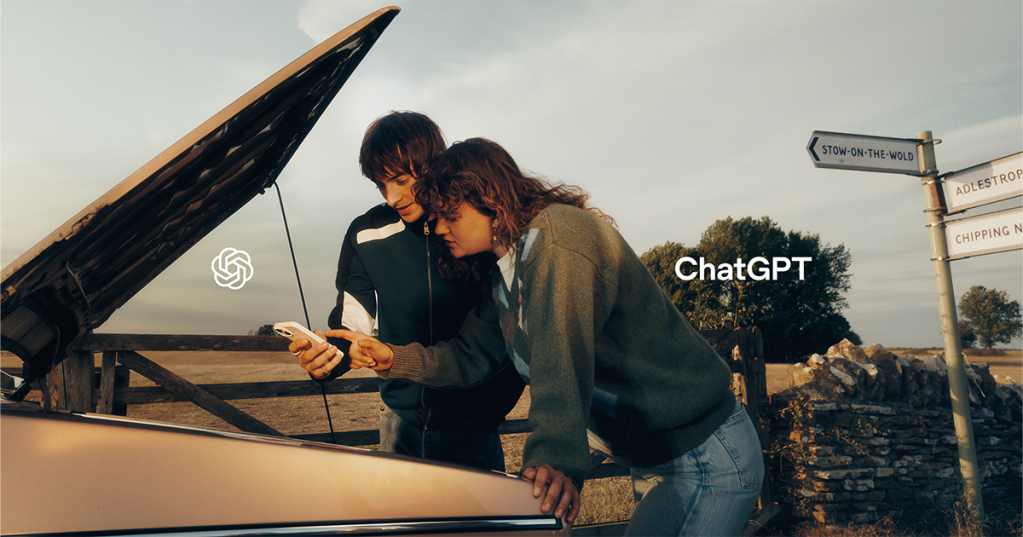 A couple consulting ChatGPT on a phone next to a car with the hood up on a rural road